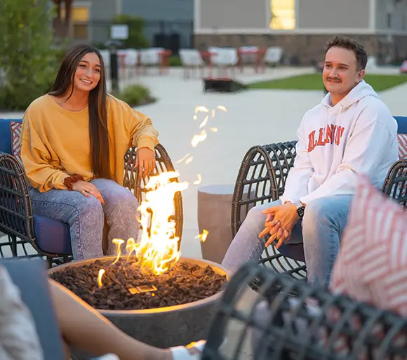young adults relaxing by a fire